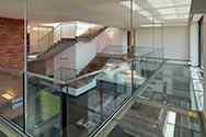 Hanging steel mezzanine with glass flooring and frameless glass balustrade with stainless top handrail