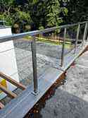 Stainless steel glass balustrade with square posts and handrail. Laminated safety glass VSG for infill