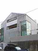 Façade covered with white marble elements mounted to galvanized steel frame