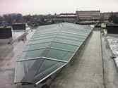 Glass roof with steel supporting structure put on roof of a residential building to cover an inner courtyard opening.
