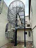 Spiral stairs from painted steel with steps from steel grid