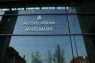 Stainless steel logo of the Auditorium Maximum on a glass partition wall