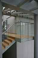 Frameless glass balustrade with stainless steel top handrail on stairs and landings