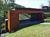 Entrance to the house and a side jutty cladded with corten steel panels