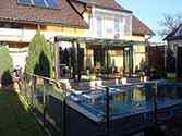 Steel and glass conservatory and glass roofing over terrace.