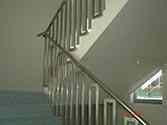 High polished, tubular stainless steel handrail supported by rectangular shaped decorative steel frames