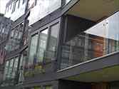 Juliet glass balconies with glass panels mounted to steel frames with standoffs from stainless steel