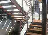 Steel staircase, wooden steps and railings with glass infill