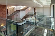 Hanging steel mezzanine with glass flooring and frameless glass balustrade