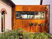corten façade, passage between buildings covered with CorTen facade cassettes