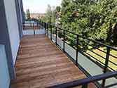 balcony with steel construction, flooring from wooden boards and steel railing with glass infill