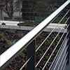 handrail from polished stainless steel tube, wire rope conducted through holes in posts
