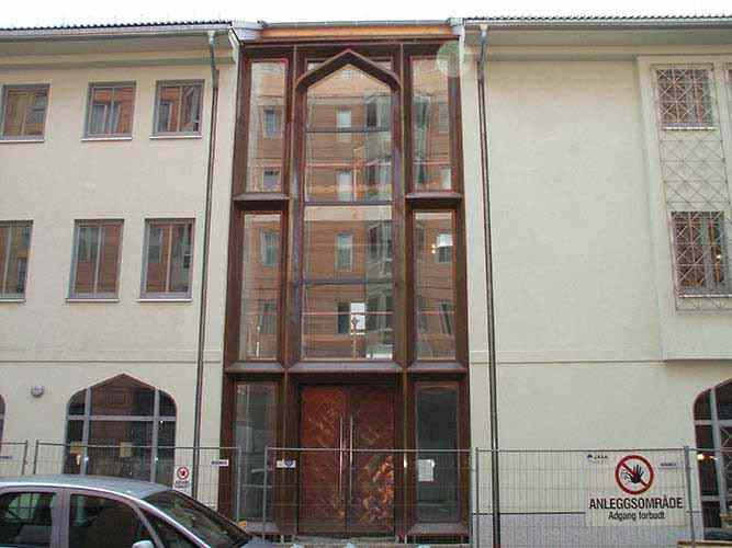 Copper door and façade with covering elements made of copper sheet mounted to a metal frame built in the wall