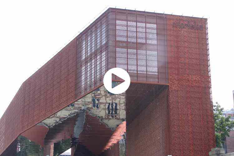 Façade cladding with perforated corten steel panels and mirrors made of stainless steel sheet.