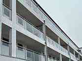 Stainless steel glass balustrade with square posts and handrail on balconies