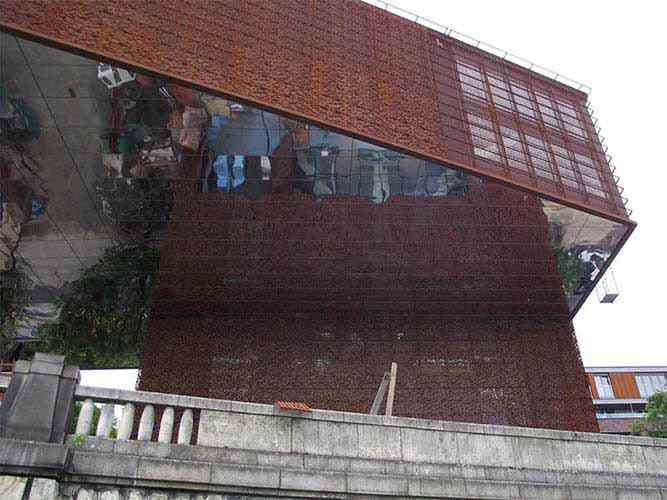 Façade covered with corten steel perforated façade panels and mirrors made of stainless steel sheet